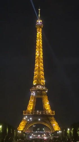 Eiffel Tower sparkles with golden lights in Paris evening