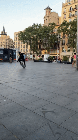Skateboarders practice tricks in Barcelona plaza evening session