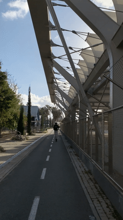 Pedestrian walks under modern canopy structure in Tel Aviv