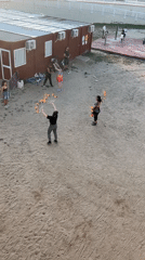 Street performers juggle fire, discs in Barcelona sandy area