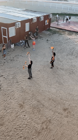 Street performers juggle fire, discs in Barcelona sandy area