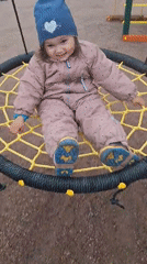 Child plays on playground swing in Timmolovo, Russia