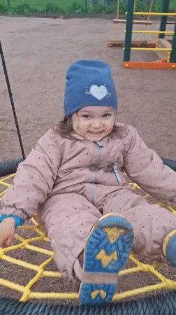 Child plays on playground swing in Timmolovo, Russia