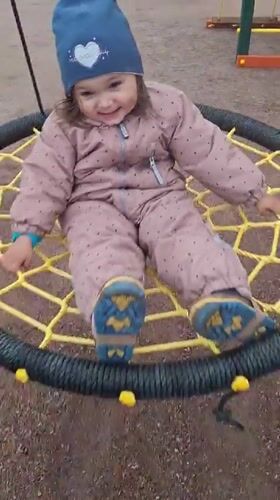 Child plays on playground swing in Timmolovo, Russia
