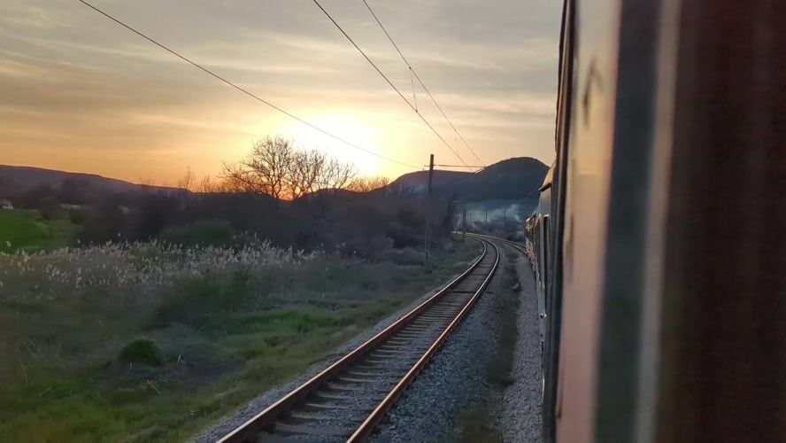 Train passenger films golden sunset view near Venchan, Bulgaria