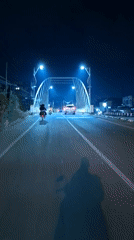 Vehicle crosses arch bridge in Lhokseumawe at night