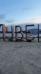 Sunset gathering at Russian lakeside features mysterious wooden letter display