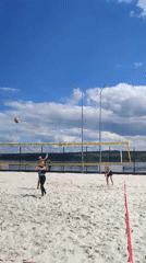 Beach volleyball match captured by witnesses on sunny morning
