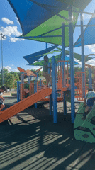 Children play on playground equipment in Grayson