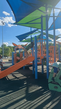 Children play on playground equipment in Grayson
