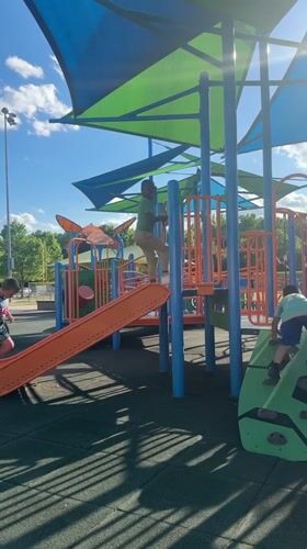Children play on playground equipment in Grayson