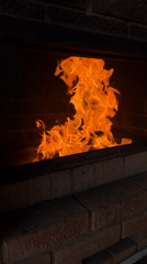 Fire burns in brick fireplace in Прикамский, Russia