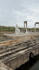 Tourist documents ancient Hierapolis ruins and statues in Pamukkale