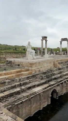 Tourist documents ancient Hierapolis ruins and statues in Pamukkale