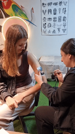 Woman gets airbrush tattoo in Kemer, Turkey
