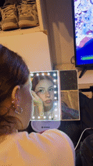 Woman applies makeup while Fortnite plays in Buenos Aires home