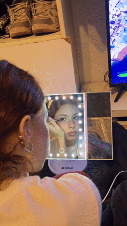 Woman applies makeup while Fortnite plays in Buenos Aires home