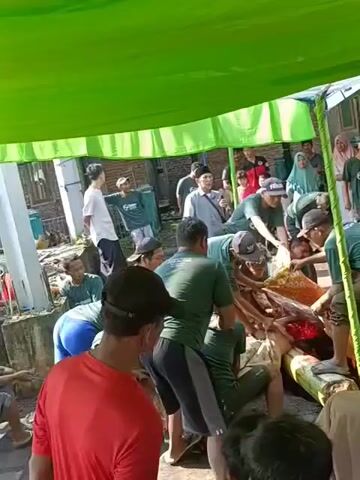 Sure, here is a brief description of the video:

The video shows a group of men gathered under a green tent, butchering a large animal carcass. They are using knives and other tools to cut the meat, and some people are observing the activity. The surrounding environment appears to be an outdoor setting.