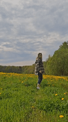 Woman spends quiet moments in Russian dandelion field
