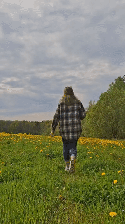 Woman spends quiet moments in Russian dandelion field