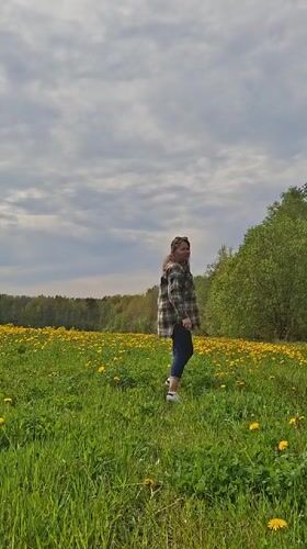 Woman spends quiet moments in Russian dandelion field