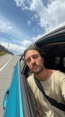 Man leans from car window on Montenegro mountain road