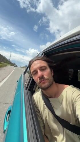 Man leans from car window on Montenegro mountain road