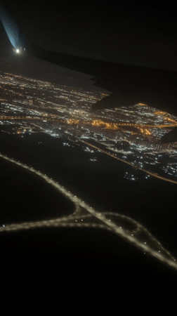 Nighttime aerial view captures illuminated Vsevolozhsk city from airplane