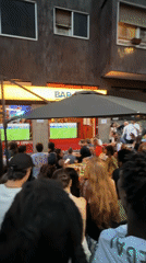 Milan crowd gathers at outdoor bar to watch big screens