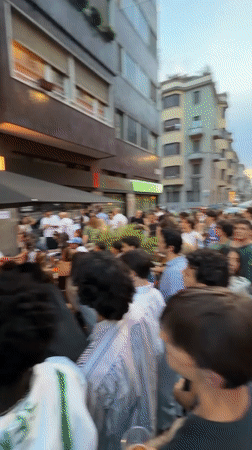 Milan crowd gathers at outdoor bar to watch big screens