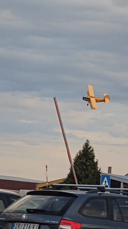 Yellow biplane flies low over Zrenjanin streets