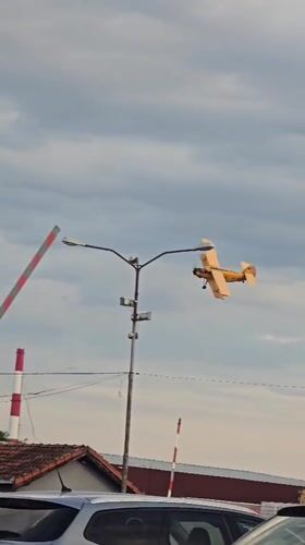 Yellow biplane flies low over Zrenjanin streets