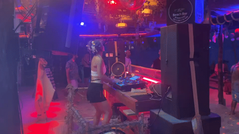 DJ performs at illuminated beach bar in Thailand