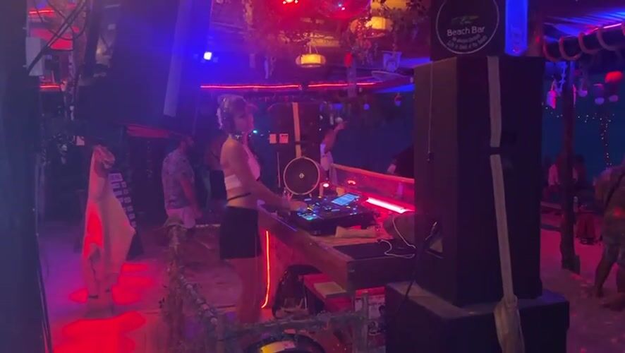 DJ performs at illuminated beach bar in Thailand