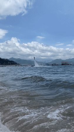 A busy beach morning in Huizhou, sand play and water sports