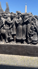 Tourists visit St. Peter's Square, view sculpture and street performer