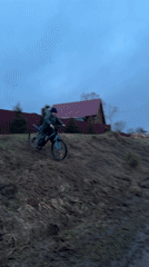 Boy rides mountain bike through muddy terrain in rural Russia
