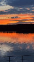 Vivid sunset reflects across calm Klyazma Reservoir