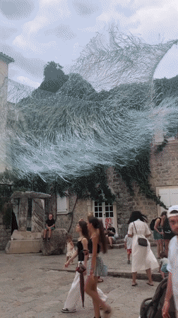 Budva's Old Town buzzes under a windswept art installation