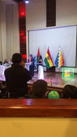 Formal ceremony with traditional-dressed speakers held in La Paz auditorium