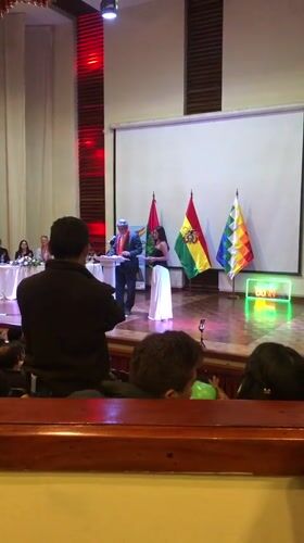 Formal ceremony with traditional-dressed speakers held in La Paz auditorium