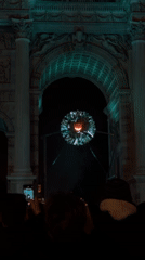 Crowd gathers around illuminated spherical art installation in Milano