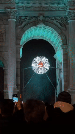 Crowd gathers around illuminated spherical art installation in Milano