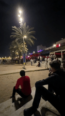 Nighttime beach activity observed in Barcelona with pedestrians and onlookers