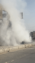 Heavy white smoke fills a Quetta street near roadside shops