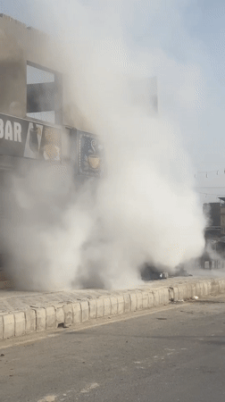 Heavy white smoke fills a Quetta street near roadside shops