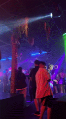 Nightclub scene captured with neon lighting, patrons dancing