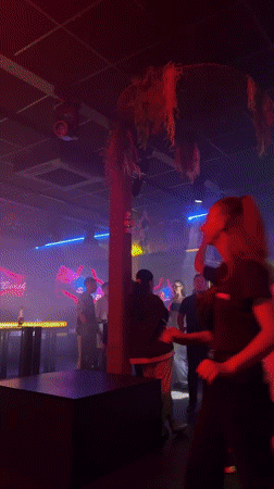 Nightclub scene captured with neon lighting, patrons dancing