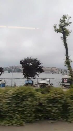Train passenger films Istanbul waterfront with boats and cityscape