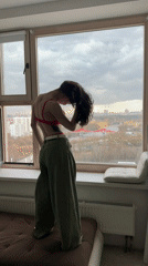 Woman in colorful attire observed at window in Khimki